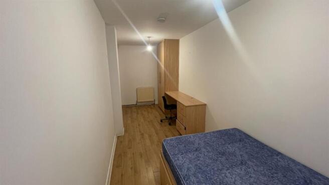 A tidy single bedroom featuring a single bed, a...