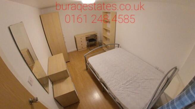 A cozy single bedroom featuring a bed and minim...