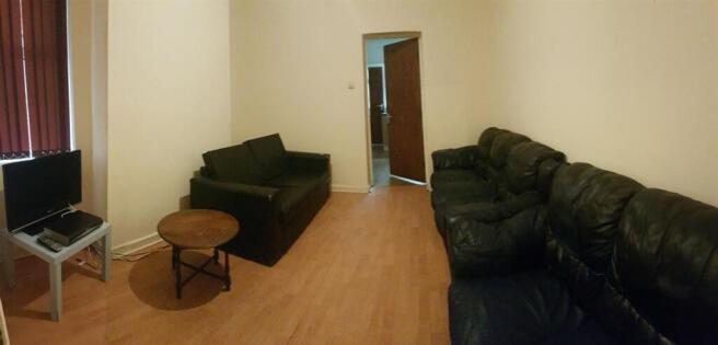 A spacious, well-lit living room with comfortab...