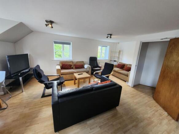 A spacious and inviting living room featuring a...