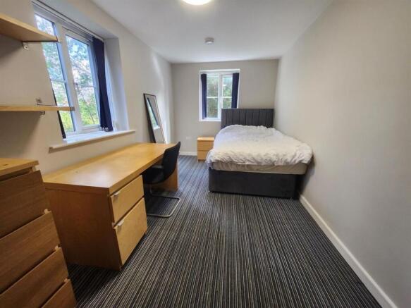 A bright and tidy double bedroom featuring a co...