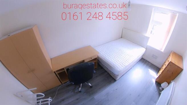 A bright and tidy bedroom featuring a comfortab...