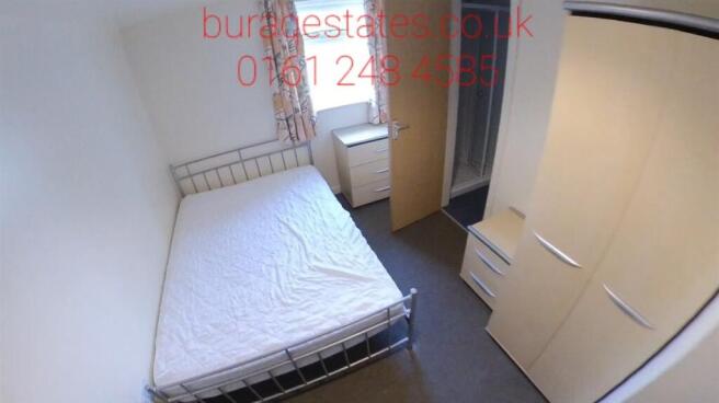 A tidy single bedroom featuring a neatly made b...