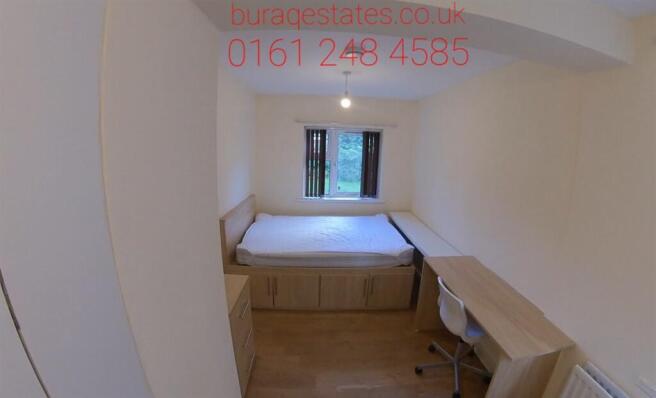 A well-lit bedroom featuring a comfortable doub...