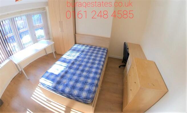 A cozy single bedroom featuring a neatly made b...