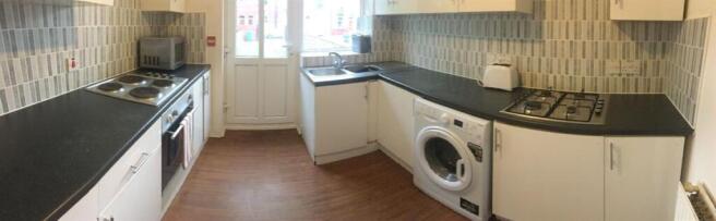 Modern galley-style kitchen with fitted applian...