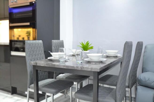 Modern dining area with a sleek grey marble-top...