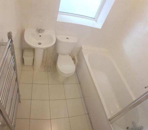 Bright, modern bathroom with a white suite, til...