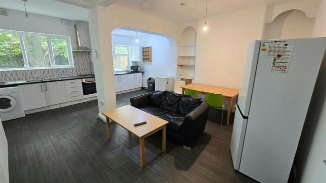 Open-plan living space with a comfortable black...