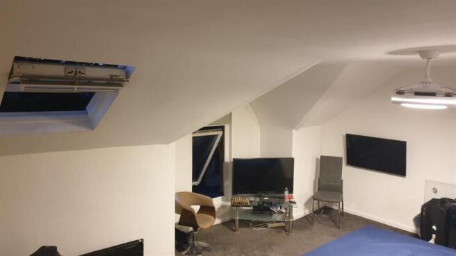 Bright attic-style bedroom with sloped ceilings...