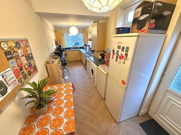 Bright galley kitchen with a long worktop, full...