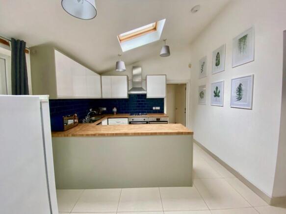 Bright modern kitchen with white cabinetry, a w...