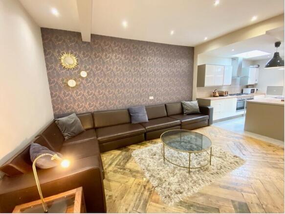 Stylish open-plan living area with a long leath...