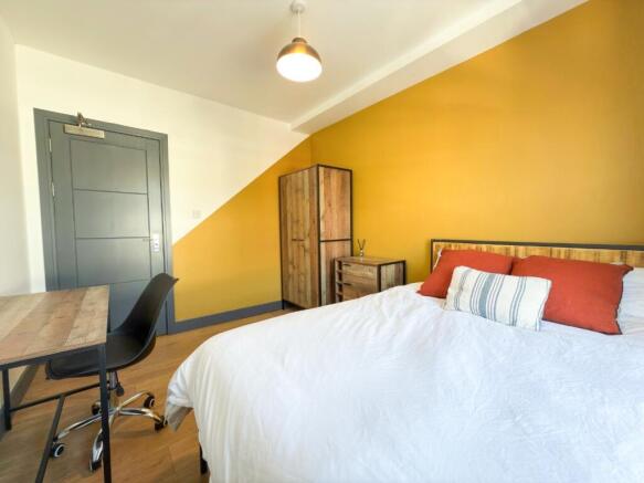 Bright, modern bedroom with a warm feature wall...