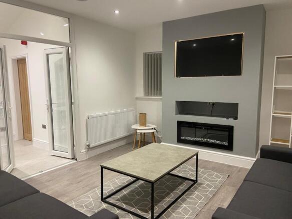 Contemporary living room with wall-mounted TV a...