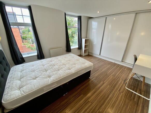 Bright, modern double bedroom with large sash-s...