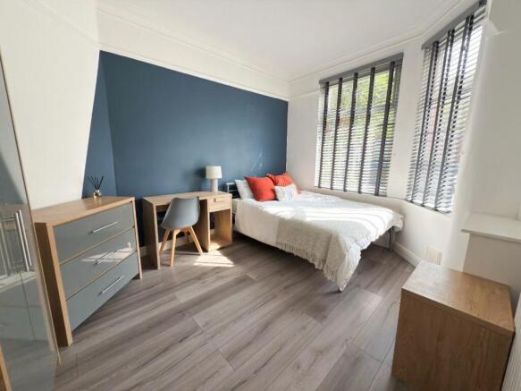 Bright, modern double bedroom with a feature bl...