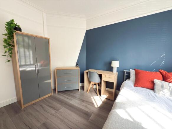 Bright, modern bedroom with a feature navy-blue...