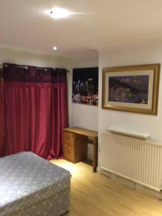 Bright, simply furnished bedroom with wooden fl...