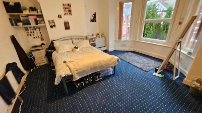 A bright double bedroom featuring a large bay w...