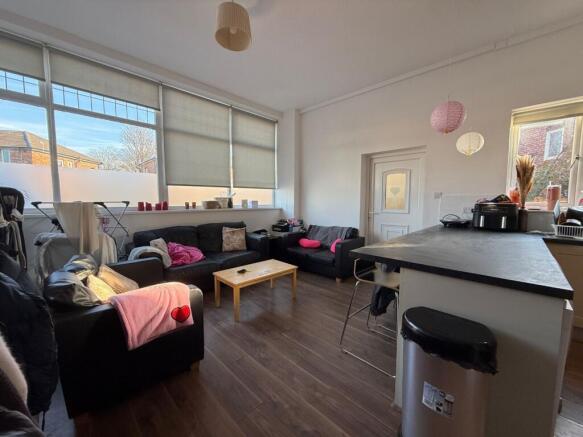 Bright, modern communal lounge with large windo...