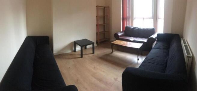 Spacious, neutral living room with two dark sof...