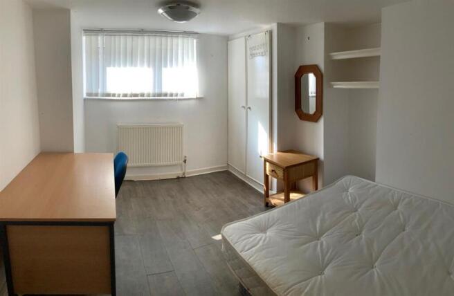 Bright, simply furnished bedroom with a double ...