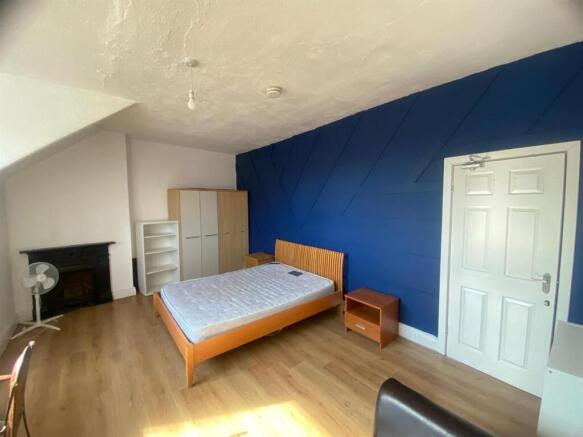 Bright, modern double bedroom with a bold featu...