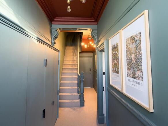 Bright, stylish hallway with decorative mouldin...