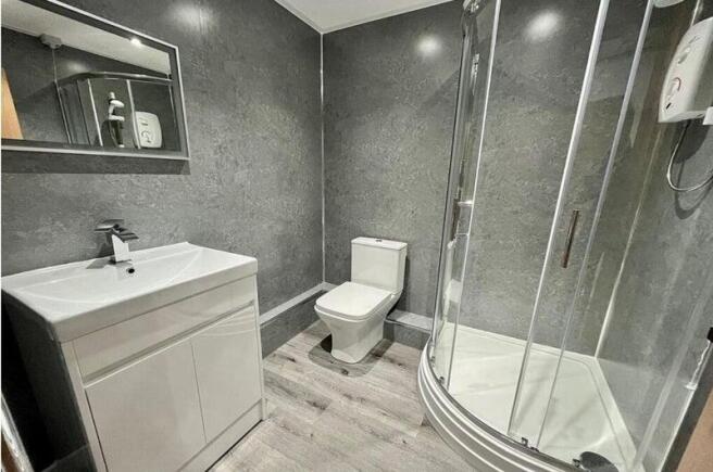 Modern bathroom with a corner glass shower encl...