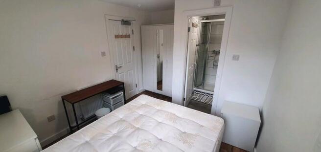 Bright, simply furnished double bedroom with a ...