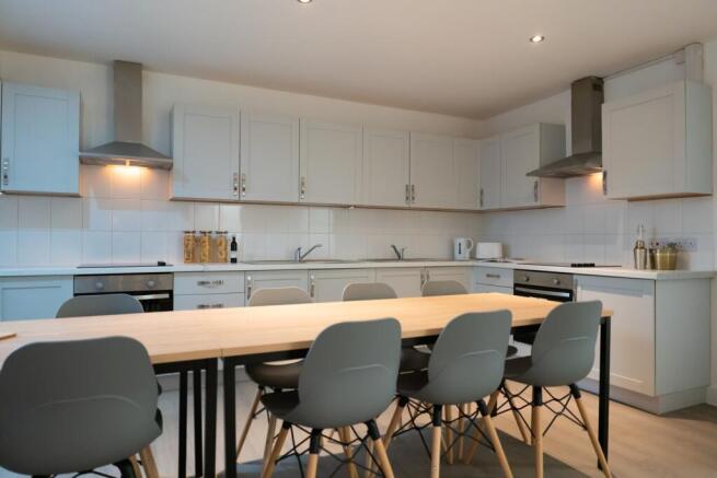 A spacious and modern kitchen featuring ample c...
