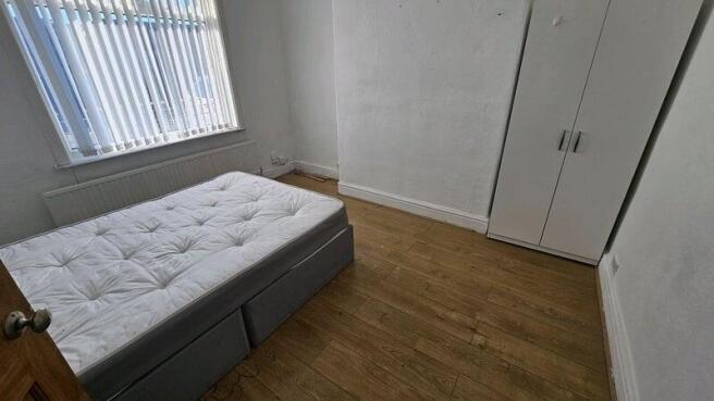 A small, tidy room with a single bed and a ward...