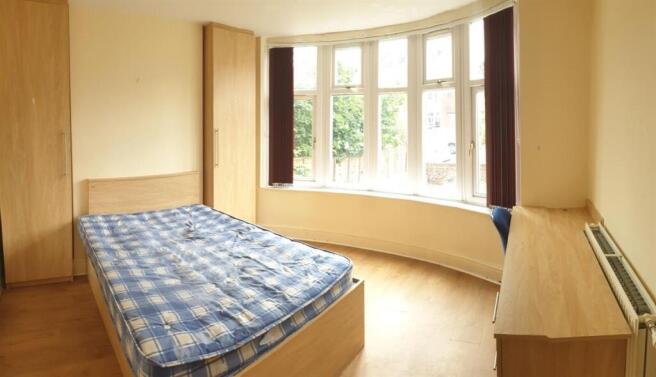 Bright double bedroom with a bay window providi...