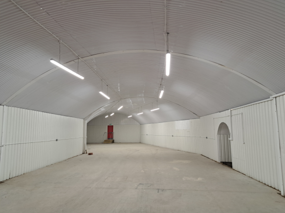 An empty arch with white lining and a fire escape door at the back.