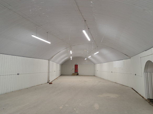 An empty arch with white lining and a fire escape door at the back.