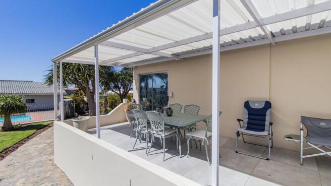 Sheltered patio overlooking the sparkling pool