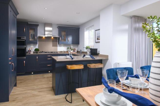 Open-plan kitchen/diner with glazed bay leading to garden in Bradgate style home
