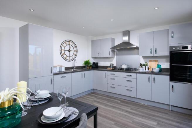 Open-plan kitchen/diner with integrated appliances and French doors leading onto garden in Ingleby s
