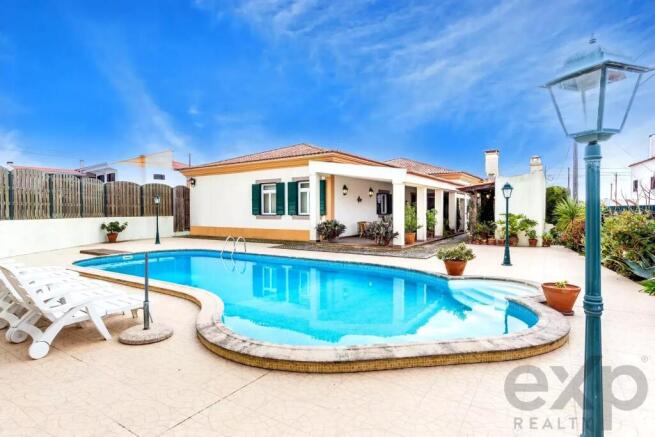 A serene poolside view of a single-story house wit