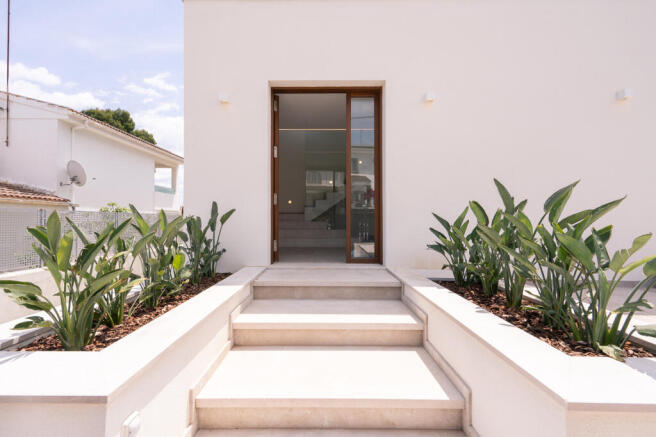 Entrance with high-quality real wood door, privacy screen and planned planting