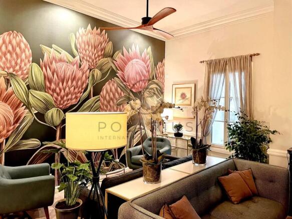 A cozy living room features a large floral mural w