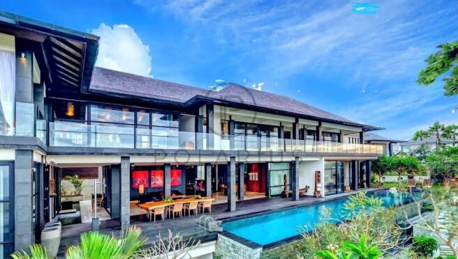 A luxurious modern villa features a large pool, sp