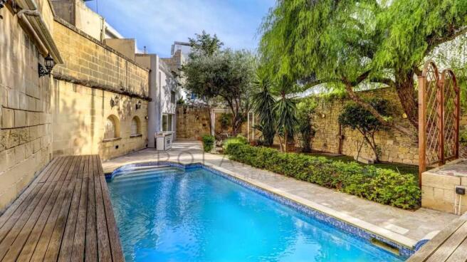 A tranquil courtyard features a blue swimming pool