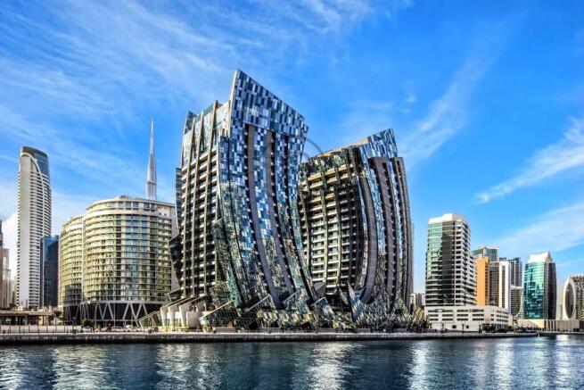 A futuristic cityscape features curving, reflectiv
