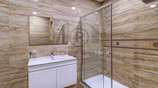 A modern bathroom with beige tiled walls features 