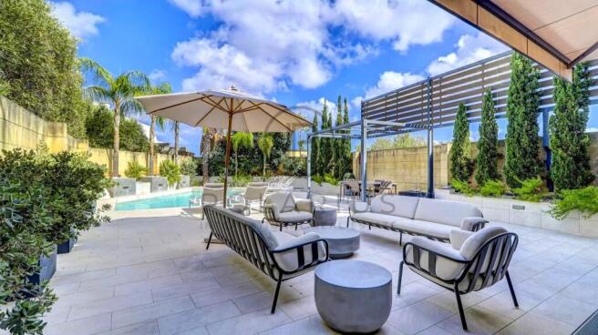 Luxurious outdoor patio with modern seating, a sun