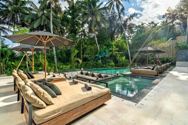 Luxurious poolside setting with lounge beds and um
