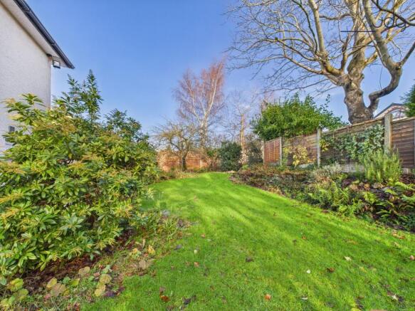 Spacious Garden with a mixture of lawn, mature shrubs, fruit trees and flagstone seating area.