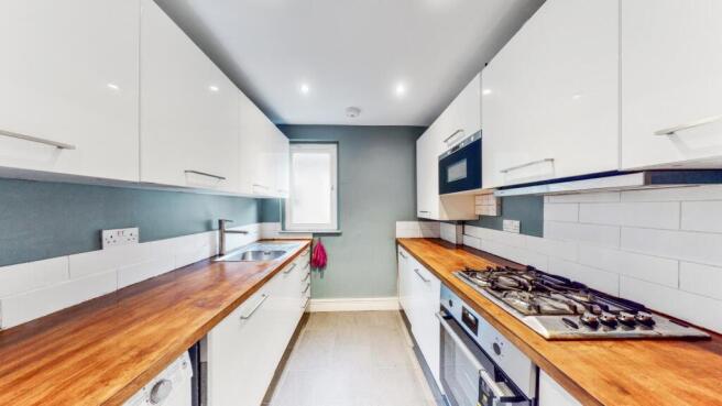 Fitted separate white lacquered style kitchen with